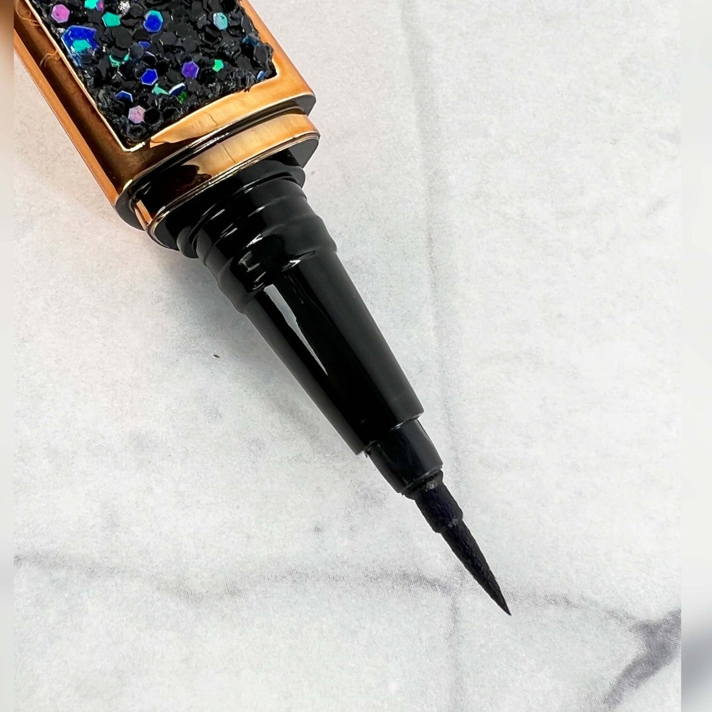 Bold and Luscious Brand Diamond Status Magic Lash is an Adhesive Eyeliner pen. The ink in this pen is black. in this picture, you see the fine tip making it easy to apply like traditional eyeliner then apply your lashes directly to the liner.