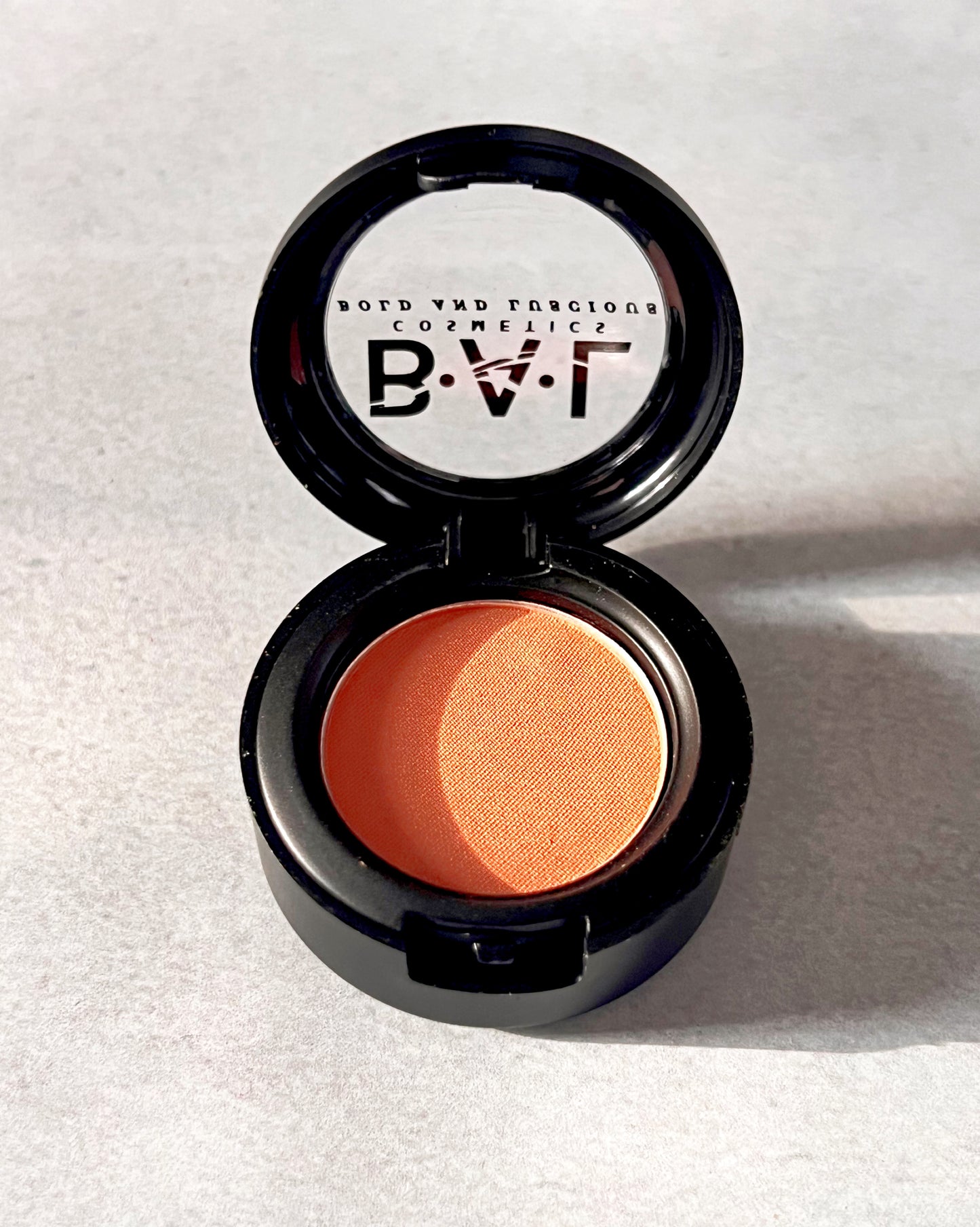 A neutral Orange tangerine pastel shade. The Bold and Luscious logo is visible. on the lid.