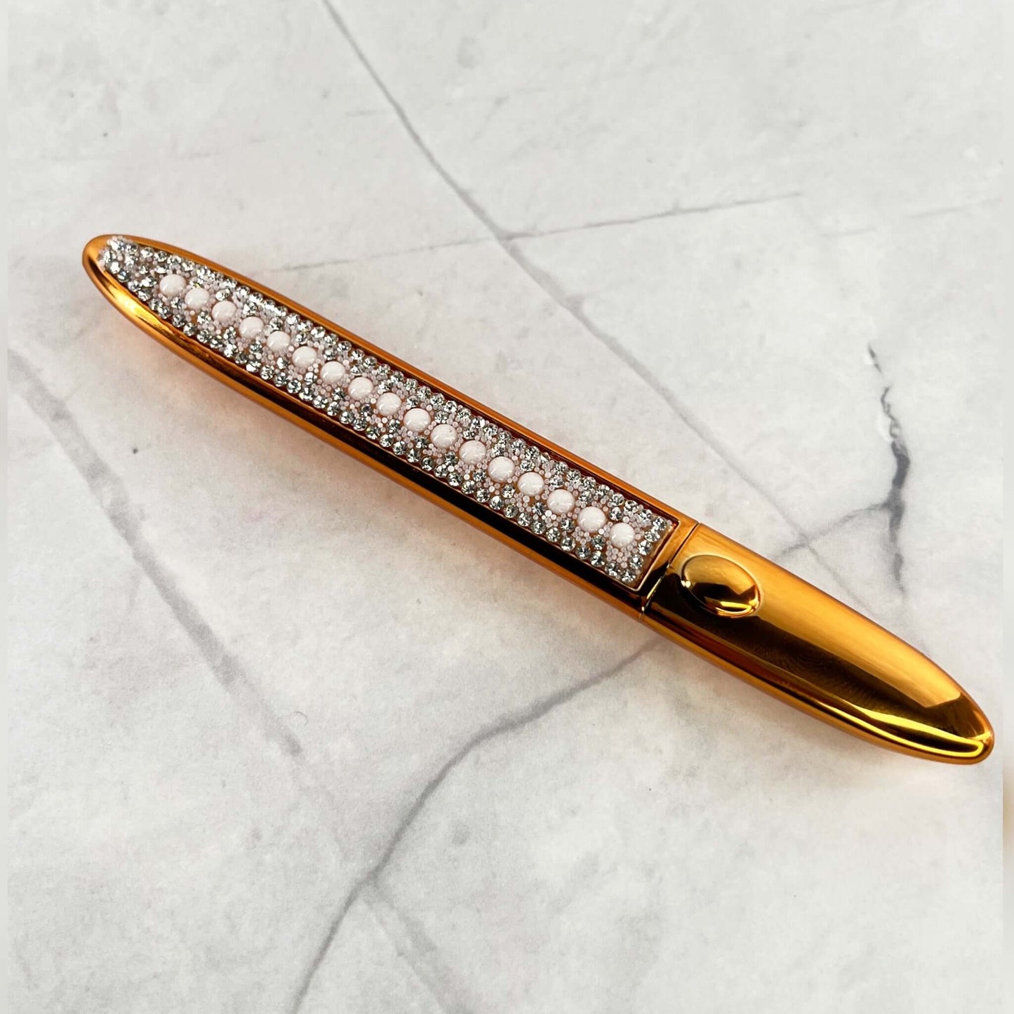 The outside of the Bold and Luscious Diamond Status Magic Lash is affixed with faux diamonds and pearls and a gold finish casing.
