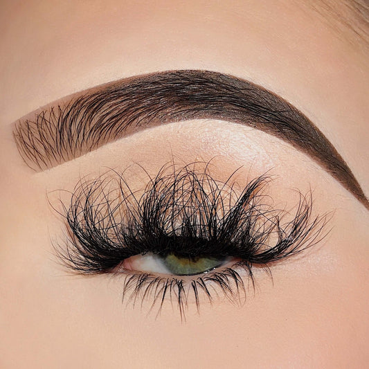 A close up of a eye revealing a fluffy lash style that is unique.  This Bold and Luscious Lash style contains lashes that lay in a wild patter, accentuating the eye. 